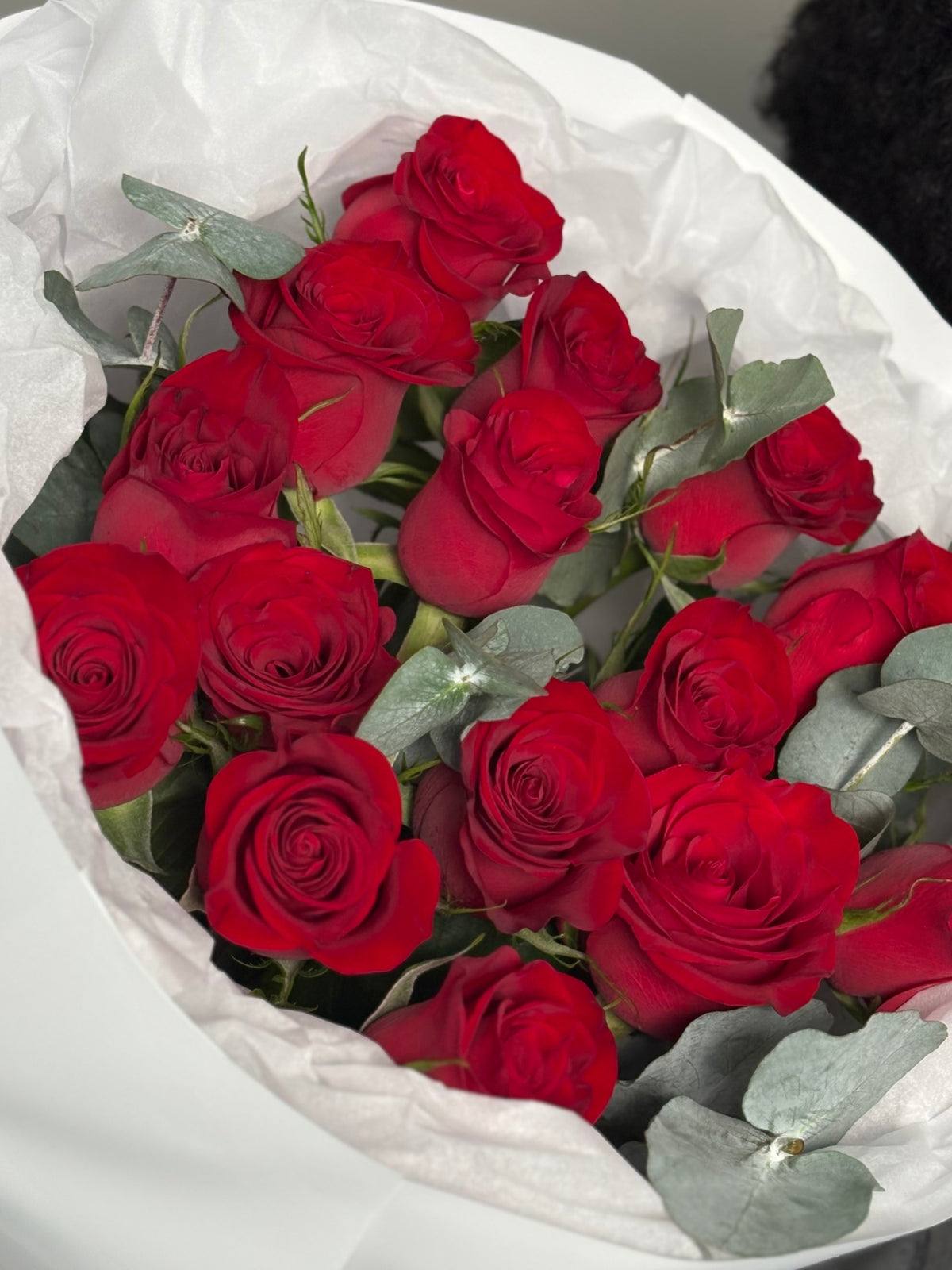 A bouquet of roses with heart balloons