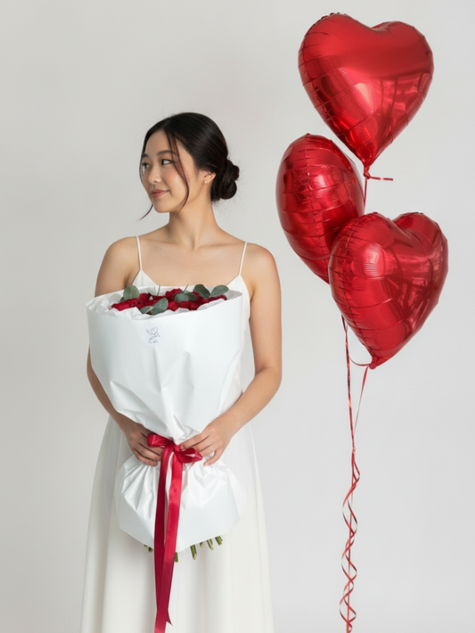 A bouquet of roses with heart balloons