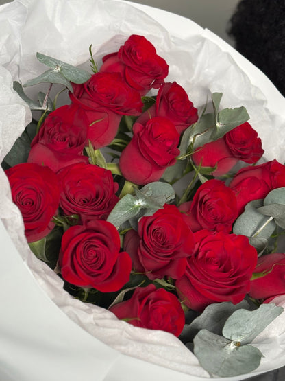 A bouquet of roses with heart balloons